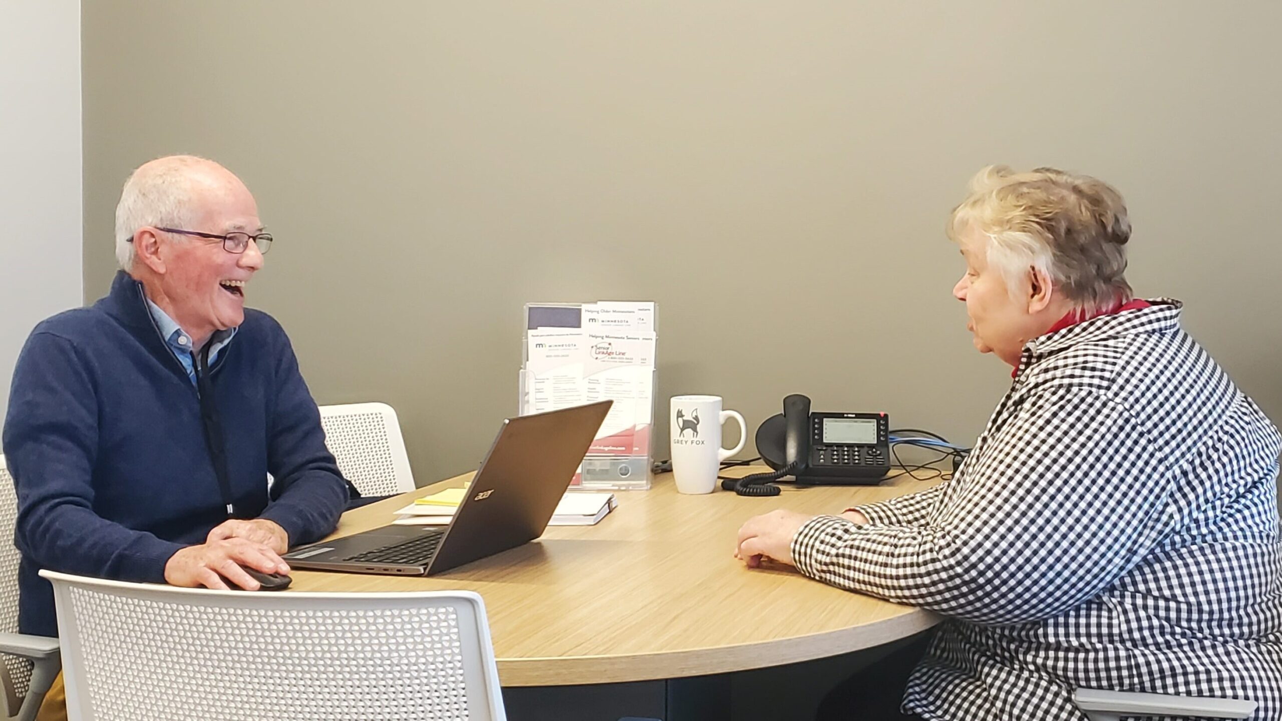 Photo of two people talking at a table.