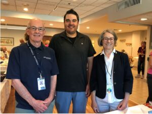 A photo of three people standing together.