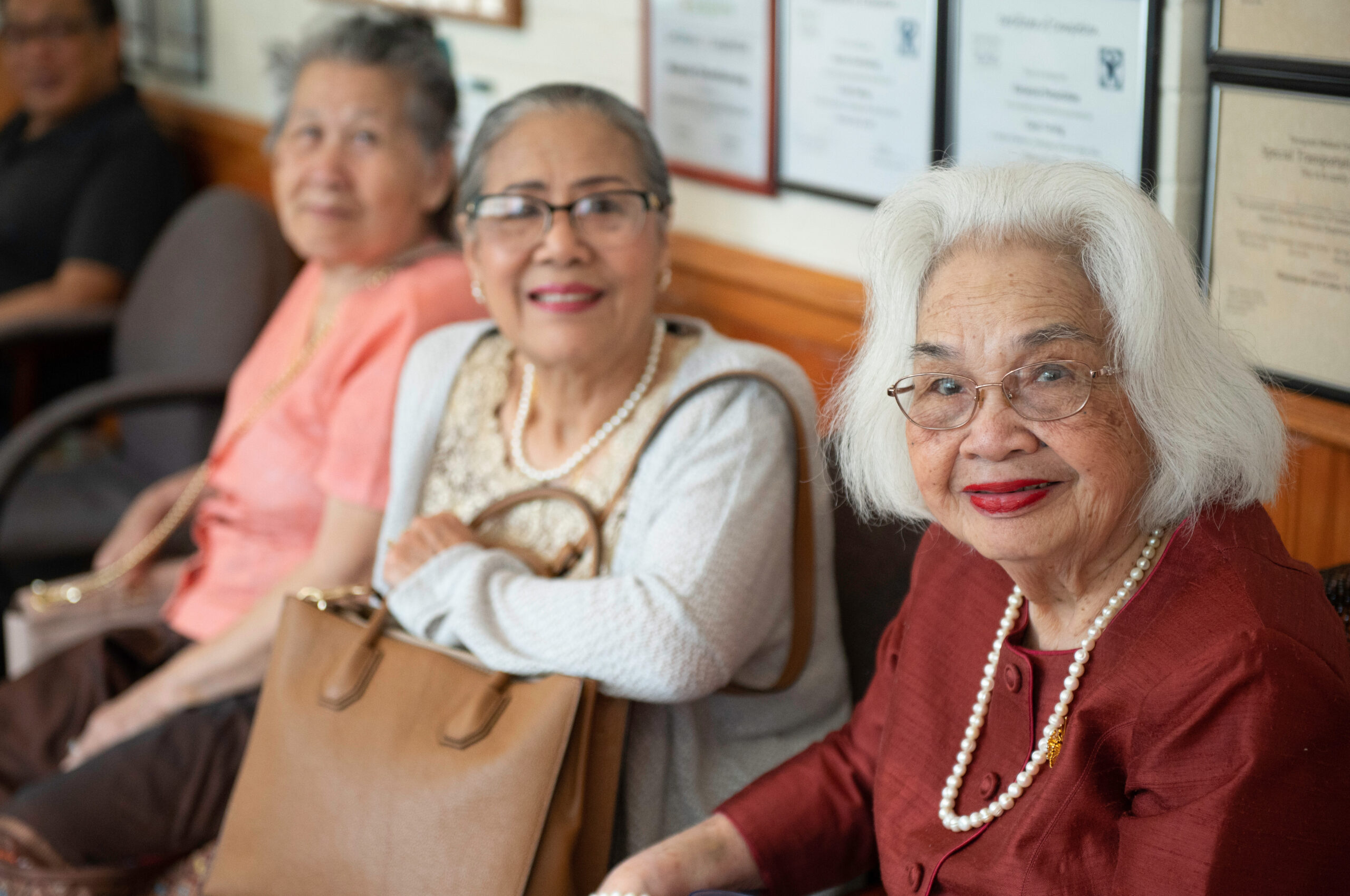 Three Asian senior women smiling at the camera.