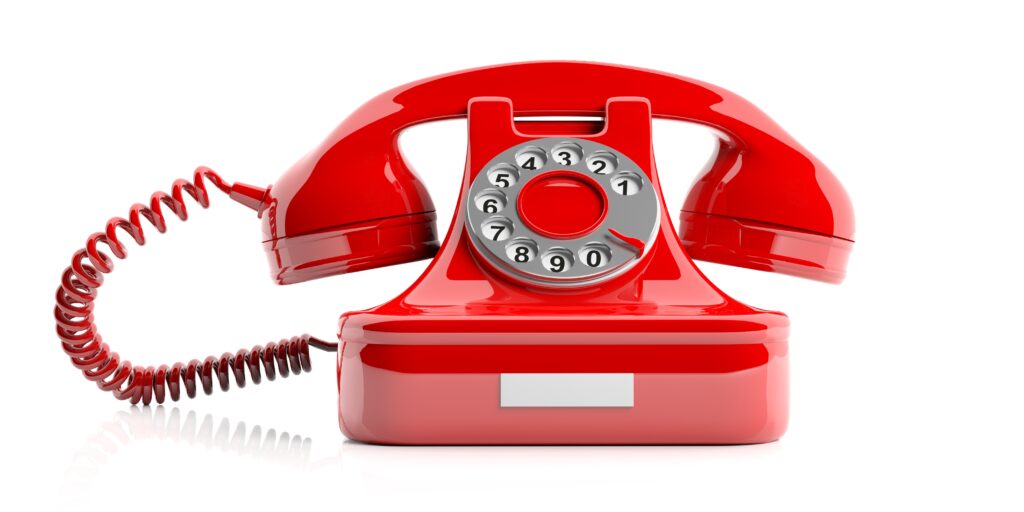 Photo of a red rotary phone.
