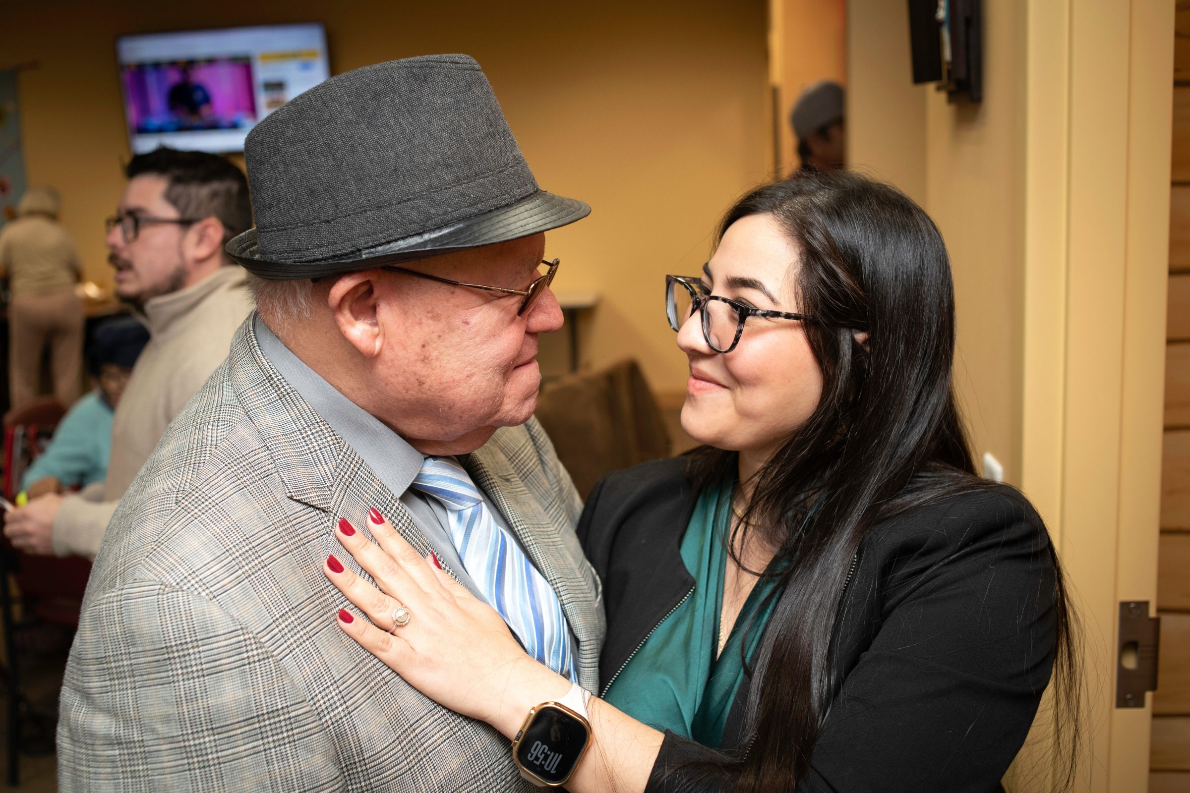 Photo of an older adult and a woman looking at each other and smiling.