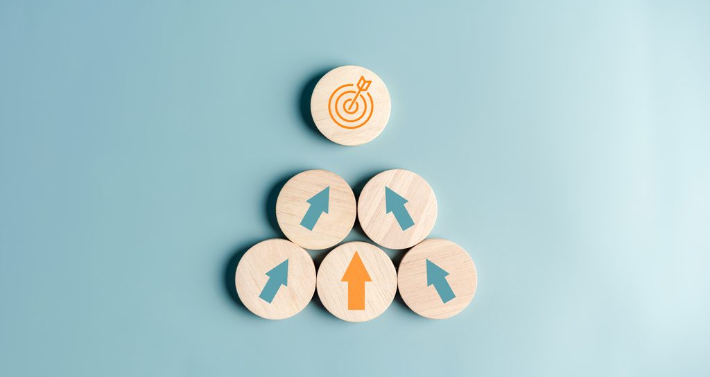 Five wooden tokens with arrows on them pointing toward another token with a target icon.